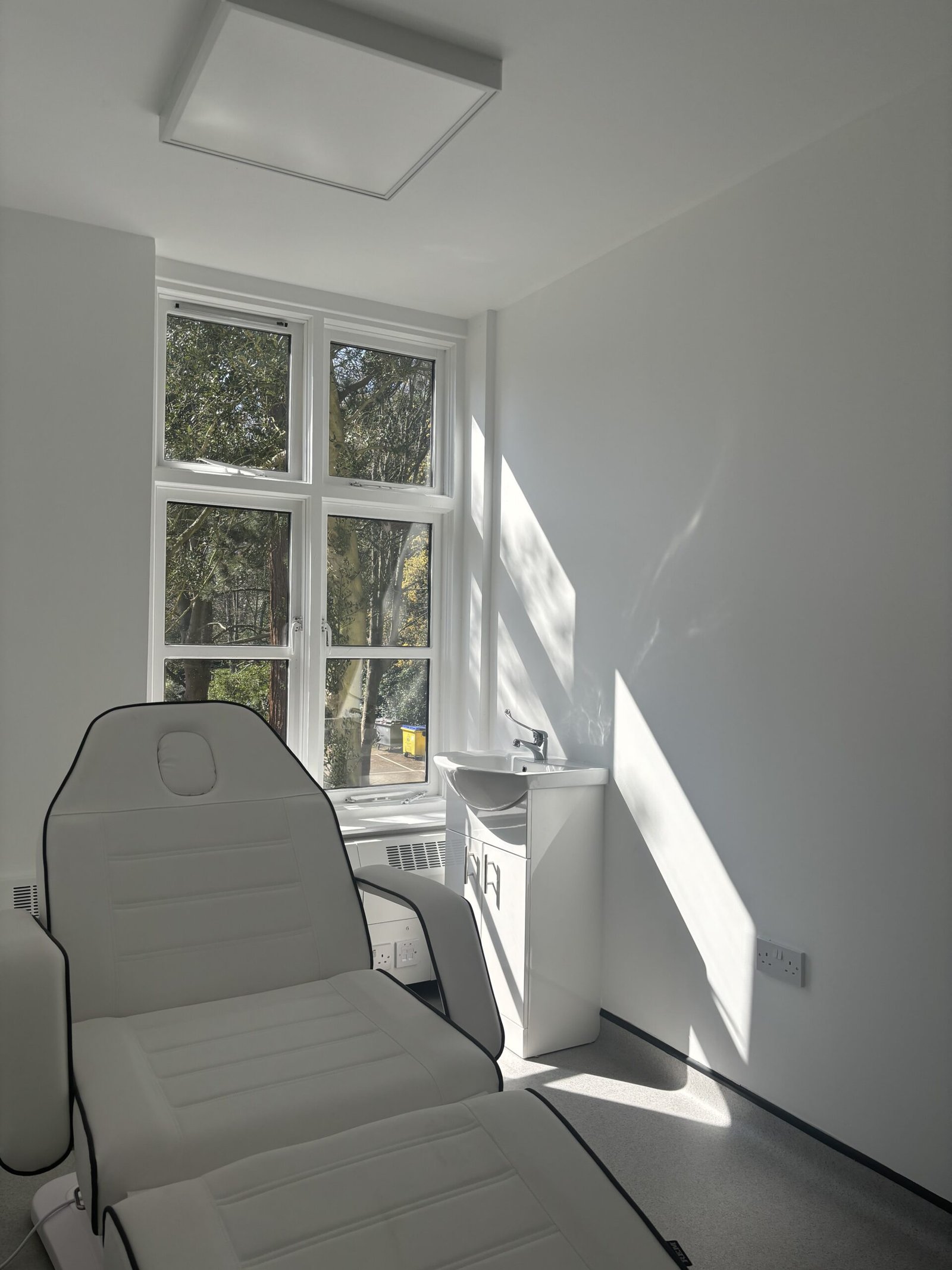 Bright, modern treatment room in the Wirral with adjustable bed 