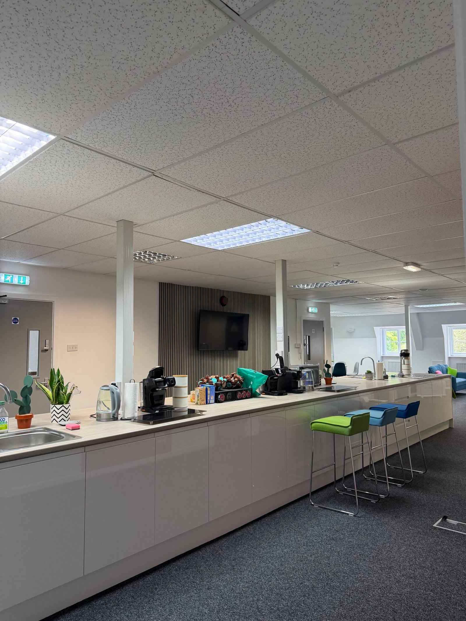 Large communal kitchen area with coffee machines, kettles and a TV
